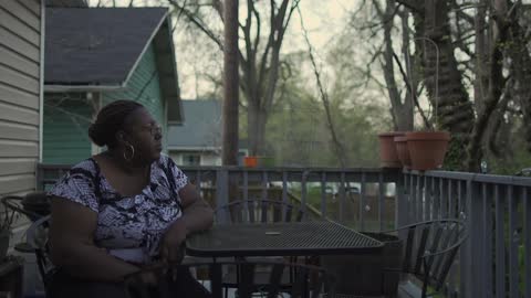 A woman sits on a patio