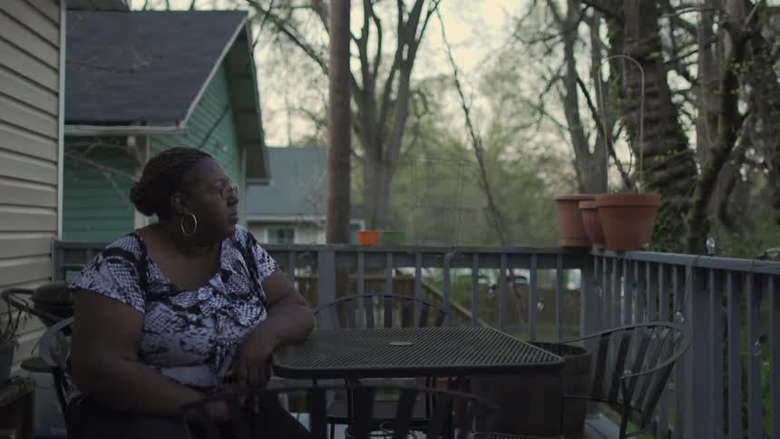A woman sits on a patio