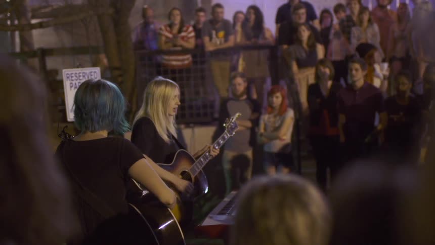 Two women perform a concert for a group of people
