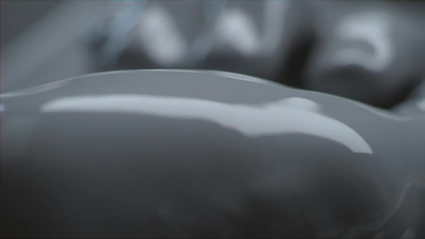 Person closing their hand that is covered in grey paint