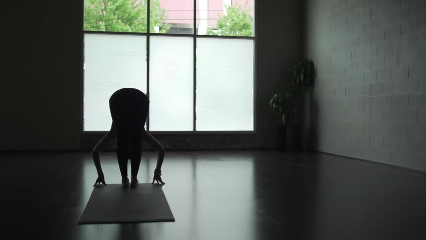 Woman doing yoga in a dark room