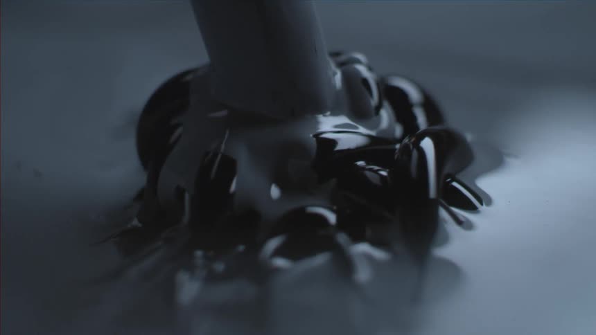 Grey and black paint is mixed in slow motion