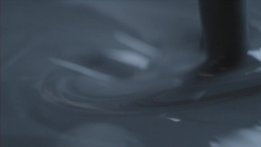 Dark liquid is stirred