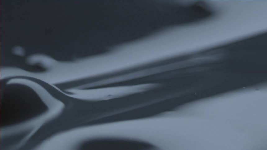 Slow motion clip of grey paint being stirred