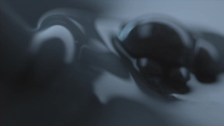 Somethings stirs a gray liquid that causes it to churn