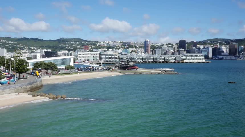 The ocean ripples in front of a city