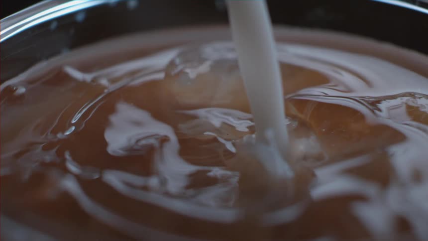 A glass of liquid with ice cubes