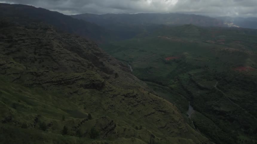 Aerial view of a valley between mountains under a cloudy sky