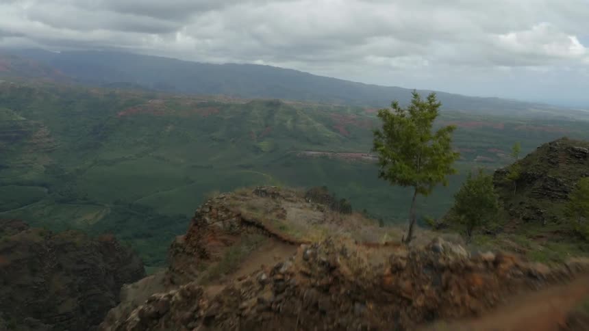 A grass covered mountain is seen from above