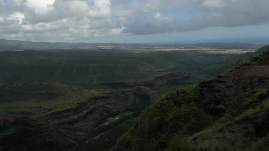 Aerial view reveals a green valley surrounded by mountains