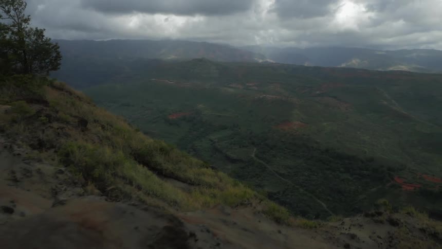An aerial view of mountains, valleys and a sky filled with storm clouds