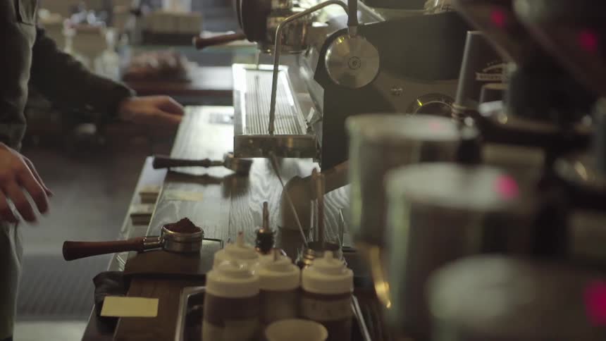 A man prepares a beverage at a coffee shop