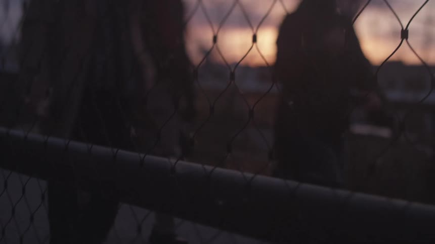 People walking along a fenced walkway in the city