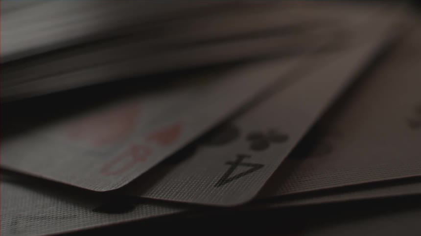 Several playing cards sit beneath papers