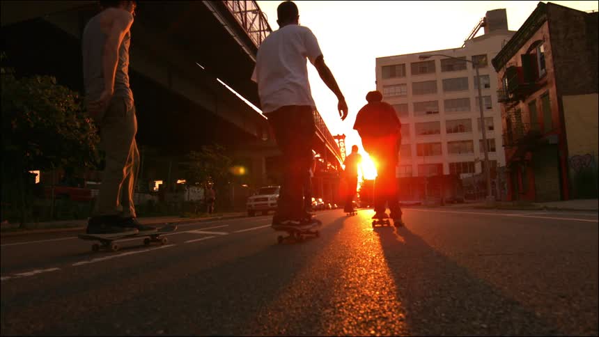 Skateboarders in slow motion at dusk