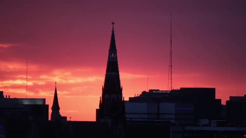 Beautifully colored sky with some spires from a city in front