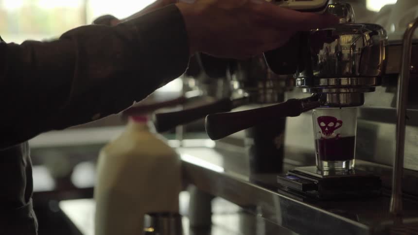 A man prepares a beverage at a coffee shop