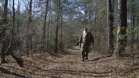 A man walks down a path in the woods