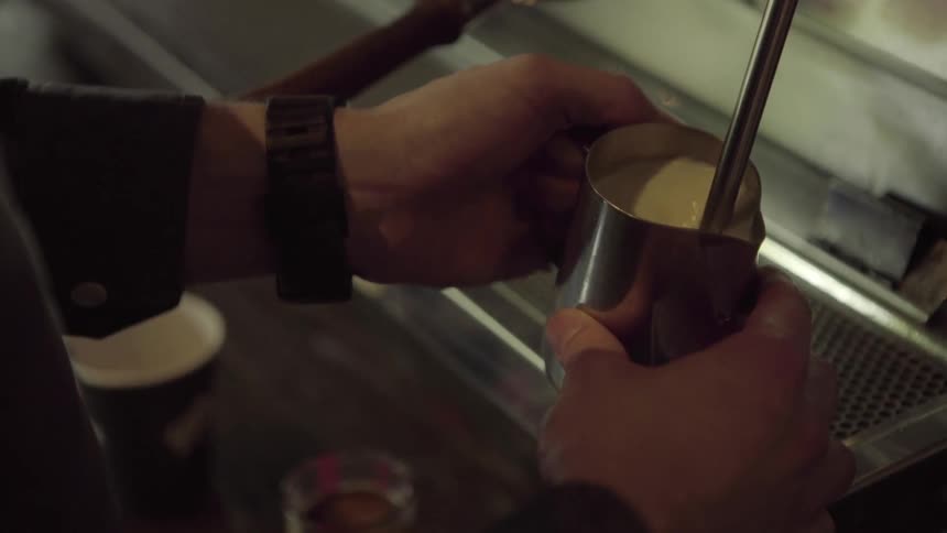 Hands holding a cup stirring the liquid