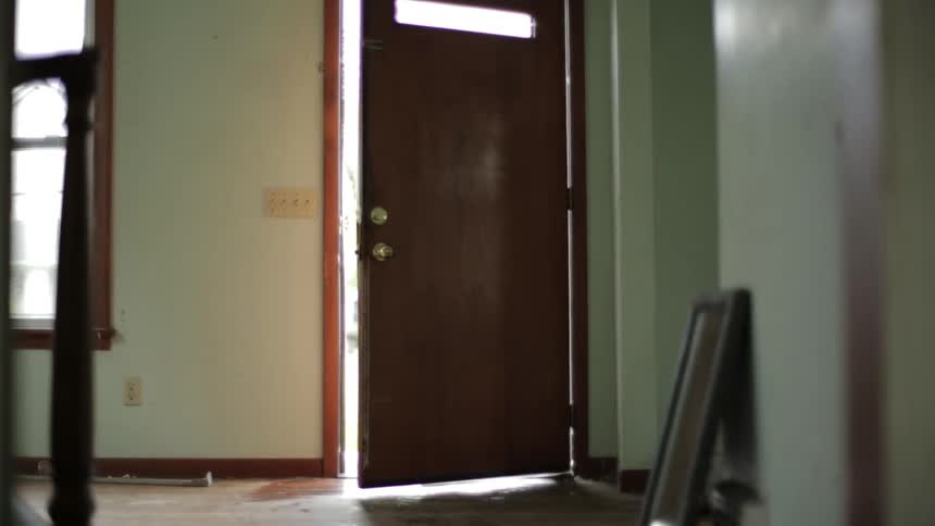 A partially open door, viewed from inside a home that appears to be vacant