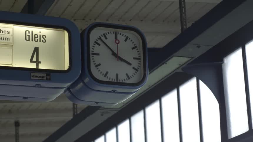 A clock ticks next to an illuminated sign