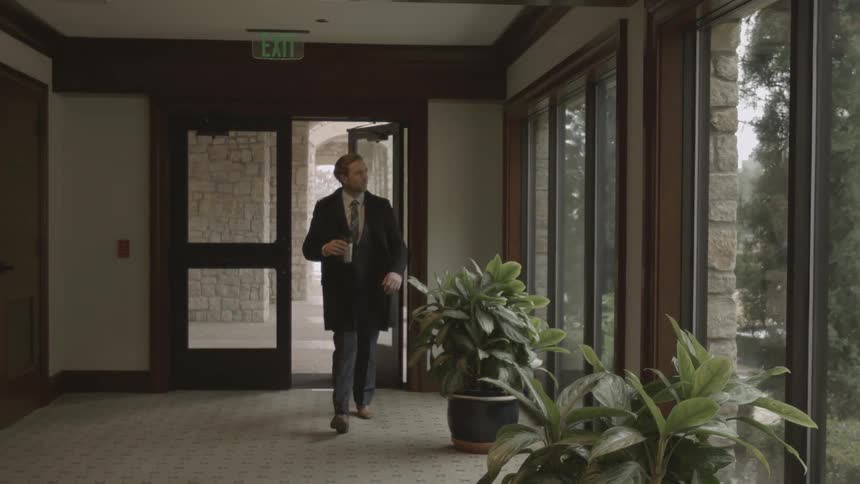 A man in a suit walks into a building