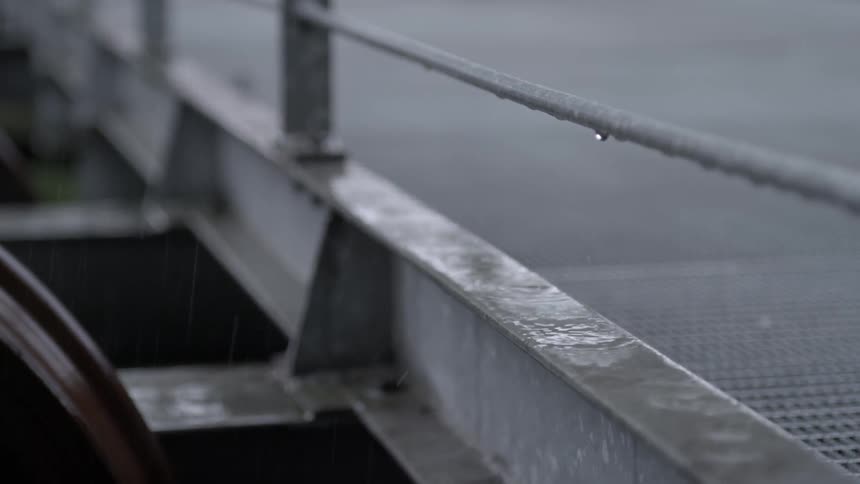 Rain drips onto a metal rail