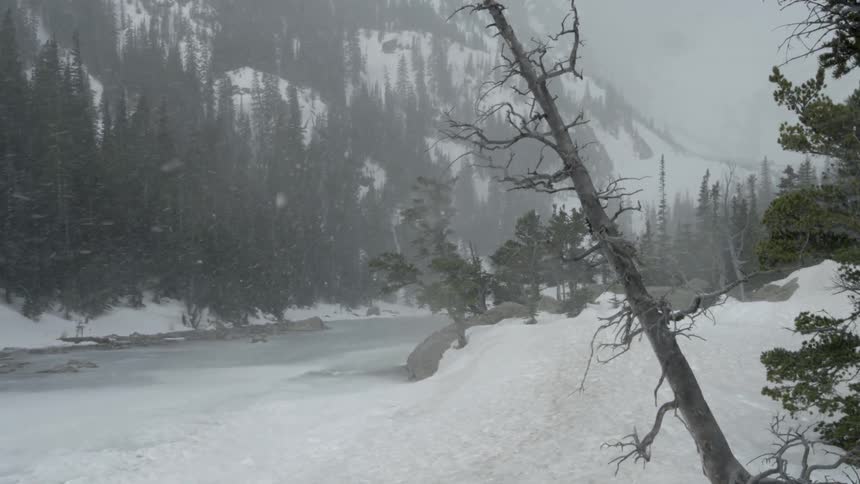 Snow is falling near a mountain