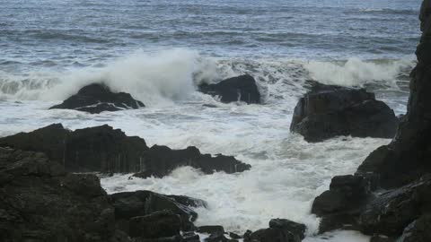 Waves crashing over and around rocks