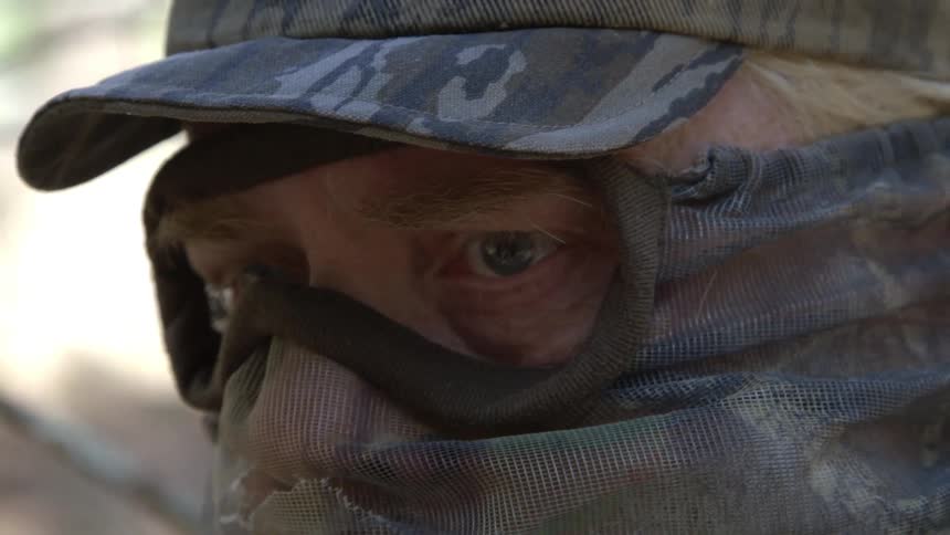An older man with most of his face and head covered in camo hunting gear