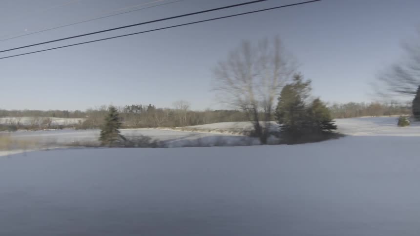 A car drives past a snowy area
