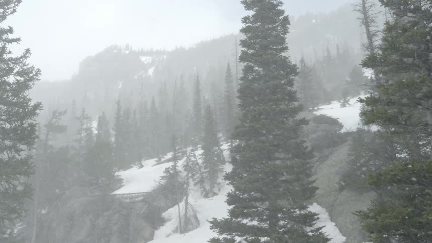 Snow falls on a mountainside