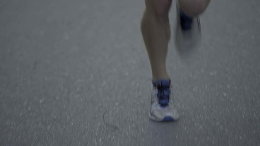 A man is jogging down the road