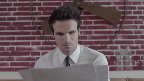A man is shuffling through pieces of paper