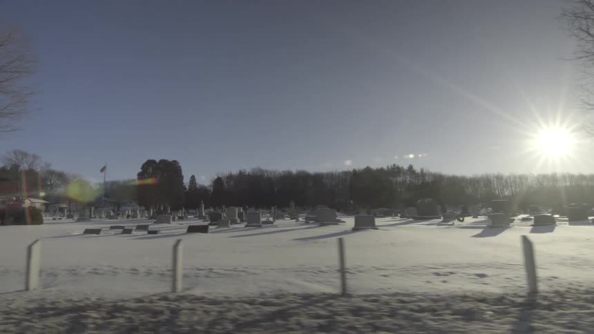 Driving past a snow covered graveyard