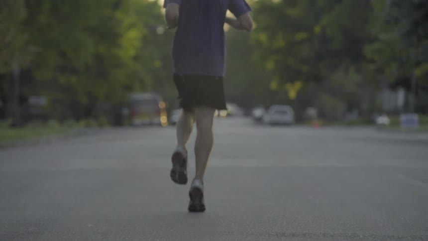 A man jogs down a street in a residential area