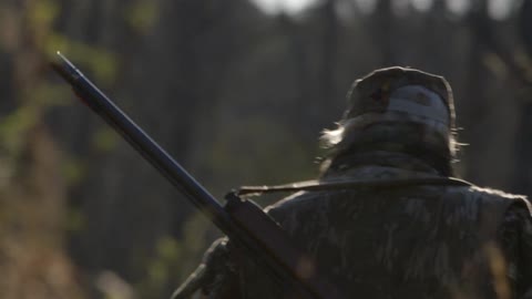 A man is hunting in a field