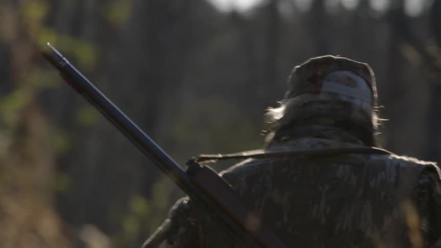 A man is hunting in a field