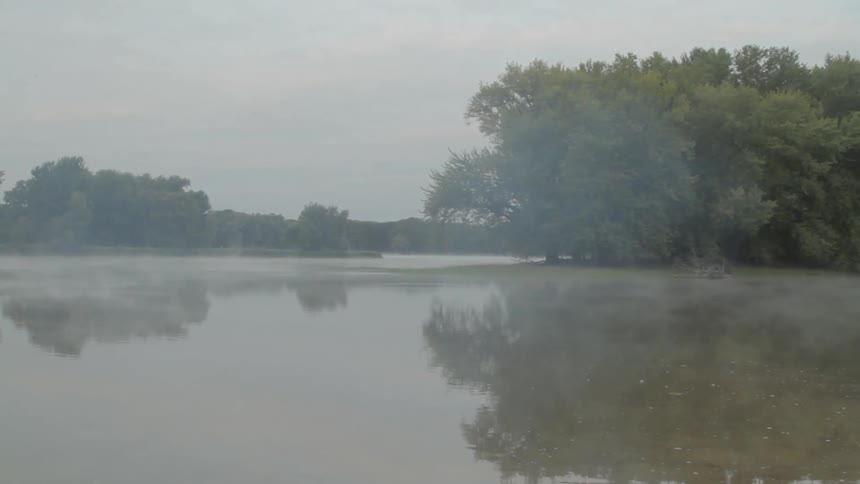 Fog rises off a lake