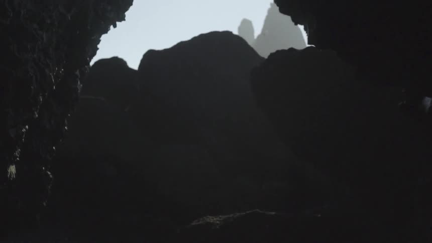 Emerging from a cavern to sunlight and a bird flying over rock formations