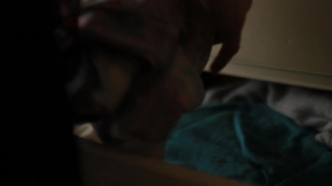 Woman opens drawer and gets a shirt out