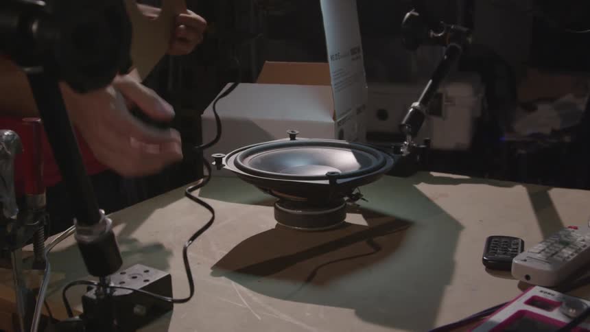 A man opens a box and removes a speaker