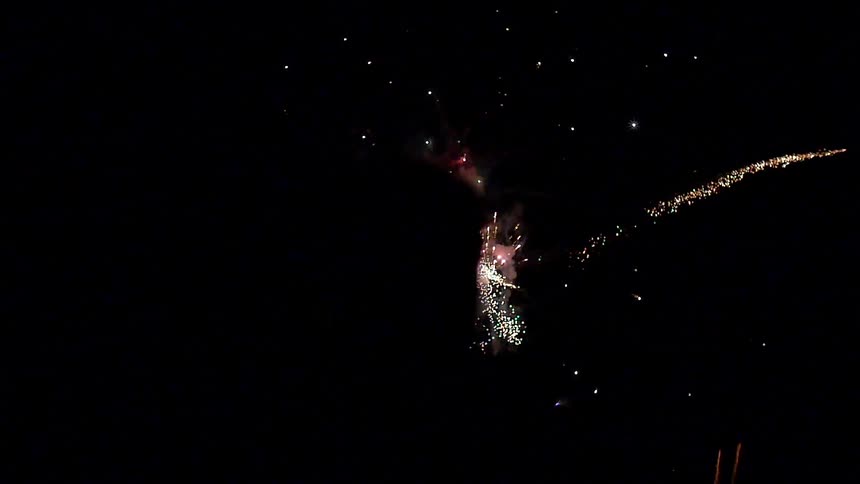 The silhouette of a man as he watches a nighttime fireworks display