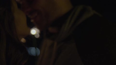 A couple kiss next to a sparkler