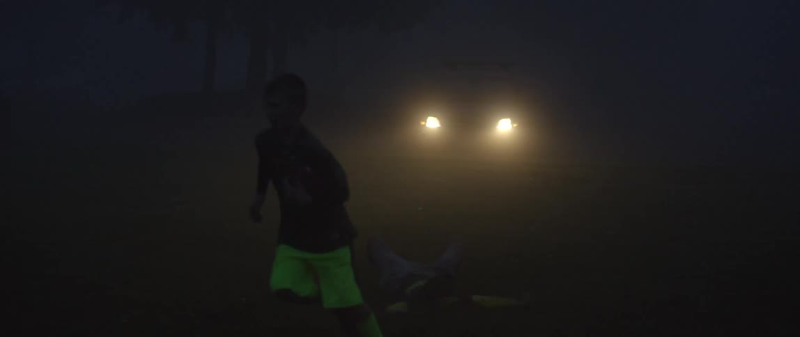 A boy jumps to catch a ball while knocking over another person