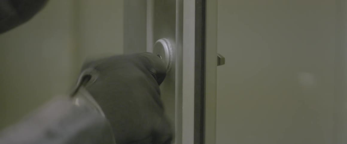 A man picks a lock and opens the door