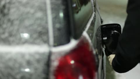 A man pumps gas into his vehicle