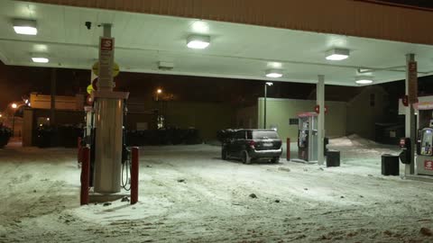 A car stops for gas in the snow