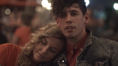 A woman lays her head on the shoulder of a man