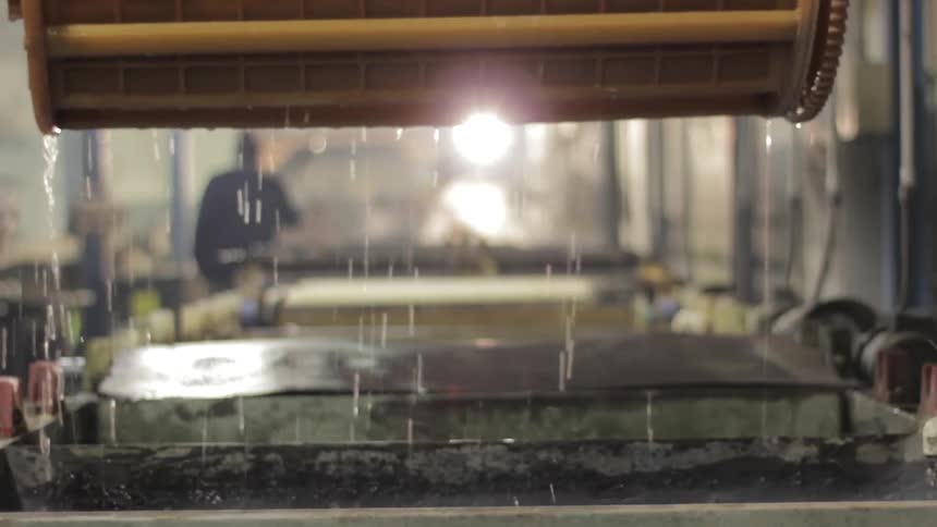 A machine lifts a component out of liquid